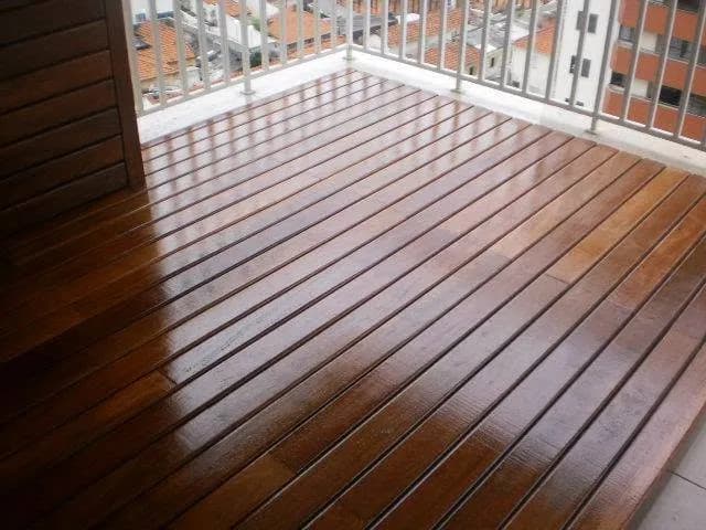 Deck de madeira com acabamento brilhante em varanda de apartamento