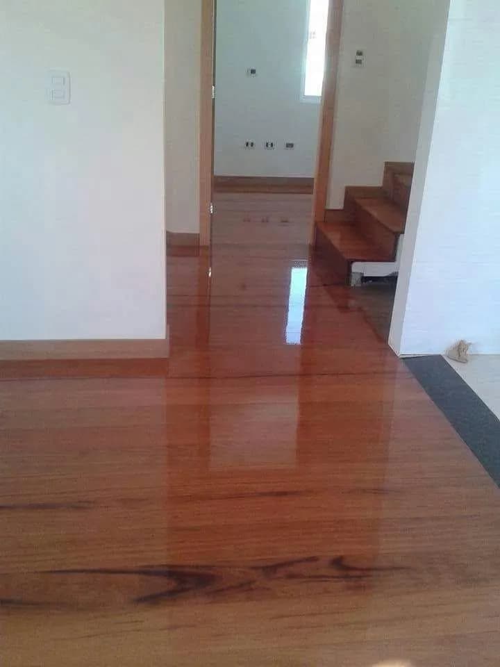 Assoalho de madeira brilhante com sinteco em corredor residencial com escada